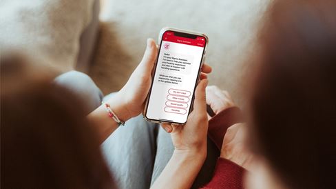 Couple looking at a smartphone screen with the Signia Assistant