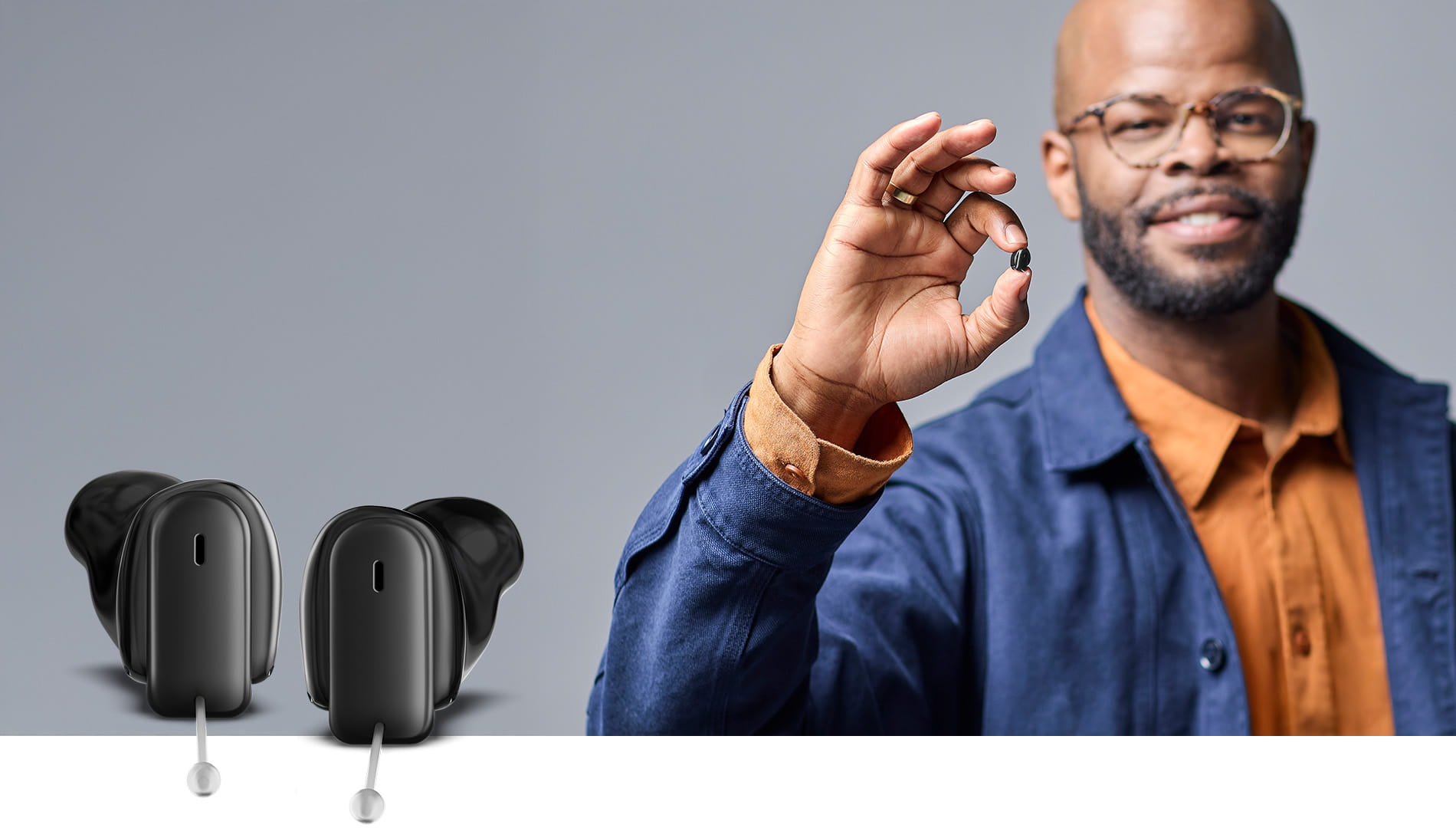 Man holding Insio Charge&Go CIC IX custom hearing aid between his fingers