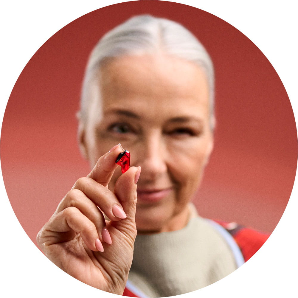 Woman holding Insio IX hearing aid