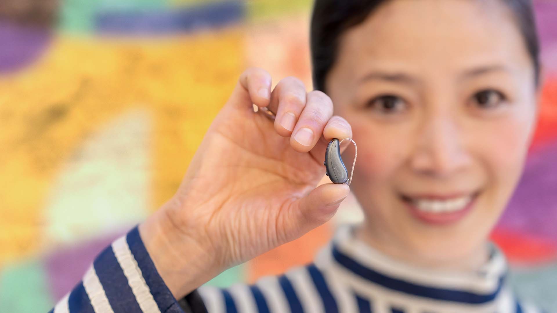 Artist holding Pure Charge&Go IX hearing aids
