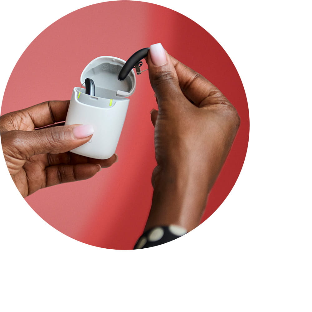 Woman taking Styletto IX hearing aids out of the charger